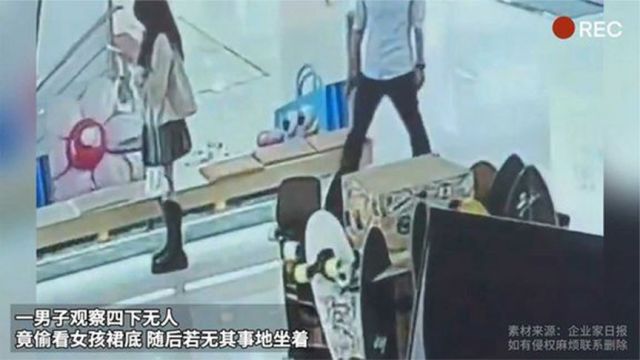 一男子观察四下无人 竟偷看女孩裙底 随后若无其事地坐着