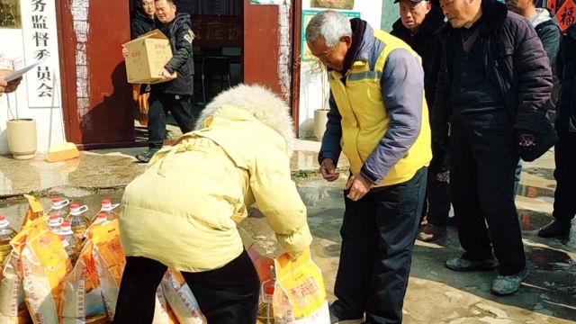 老人在睢县白楼乡西岗村村室领东西.