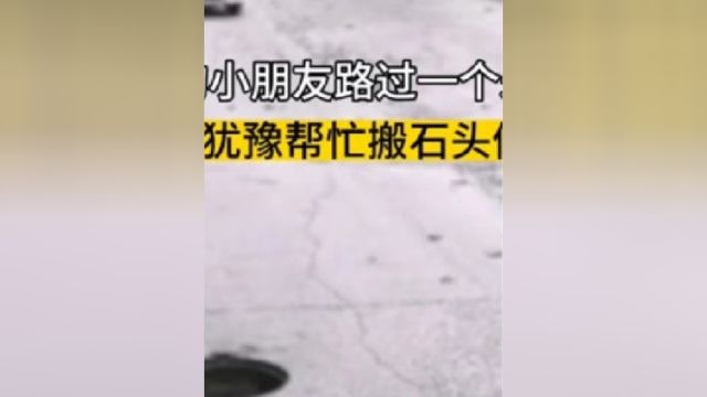 两个小朋友路过一个未盖的井口,他们毫不犹豫帮忙搬石头做警示标志