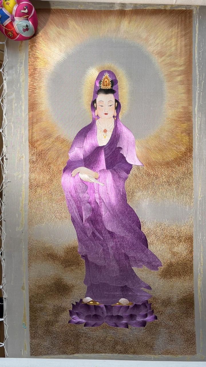 观音开相是非常难的,这幅紫衣观音是用1丝-几毛开脸,绣出观音的端正与