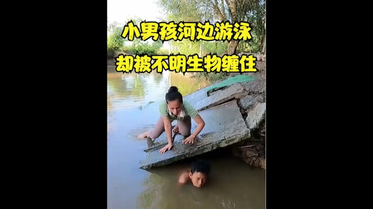 小男孩河边游泳被不明生物缠住