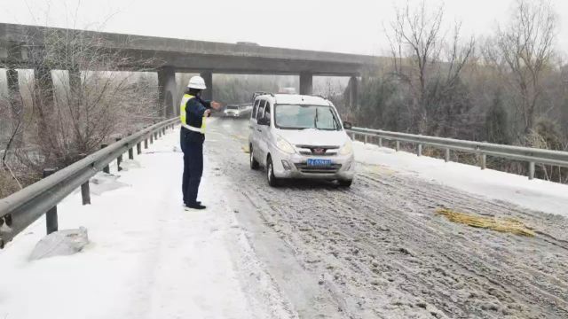 2月20日极端低温冻雨天气,辖区互通桥面打滑,许平南高速路产队员在路面指挥交通,志愿服务过往司乘安全通行